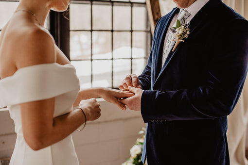 groom putting the wedding ring on his bride's ring finger